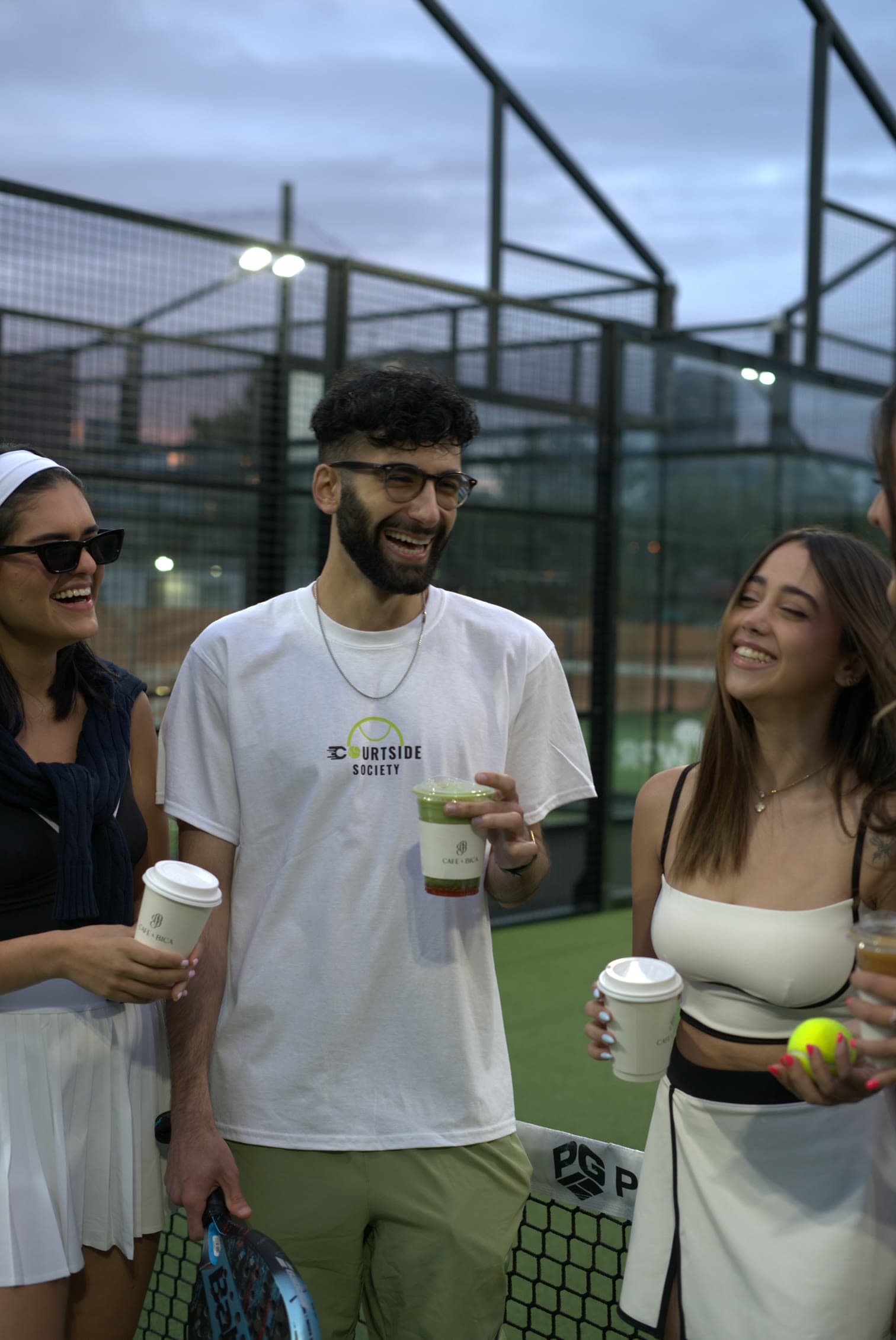 Members laughing at the net, coffees in hand